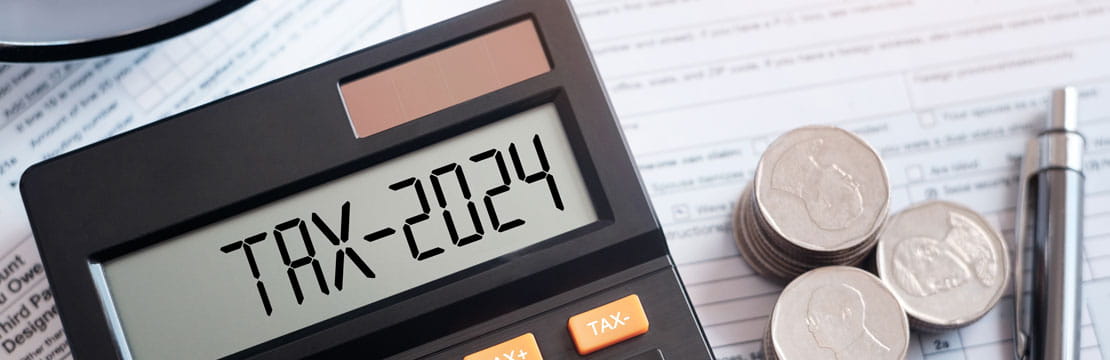 The word "Tax 2024" on a calculator on some documents.